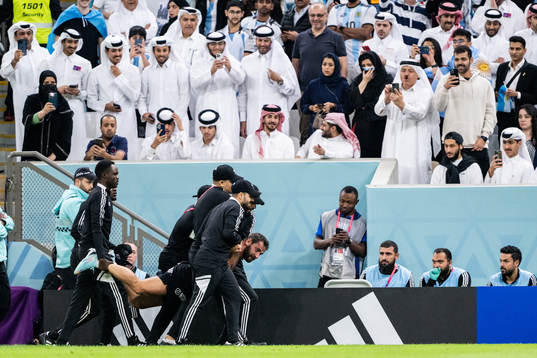 A pitch invader is detained by security