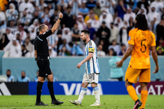 Lionel Messi of Argentina is shown a yellow card by referee