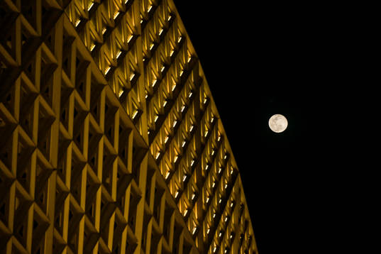 A full moon is seen behind Lusail Stadium