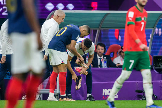 Kylian Mbappe of France changes his shoe
