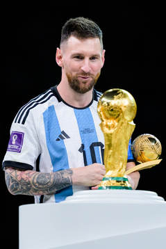 Lionel Messi of Argentina looks at the FIFA World Cup Trophy