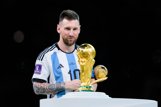 Lionel Messi of Argentina looks at the FIFA World Cup Trophy
