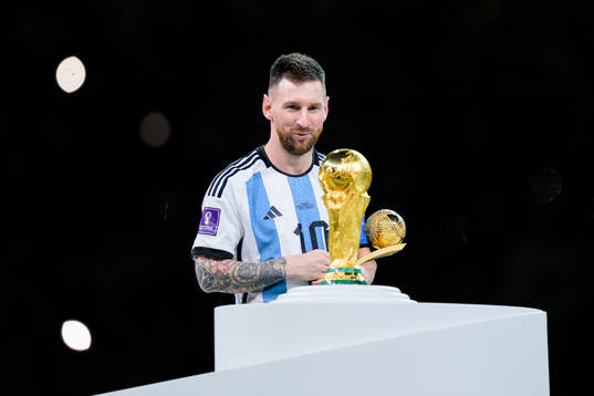 Lionel Messi of Argentina looks at the FIFA World Cup Trophy