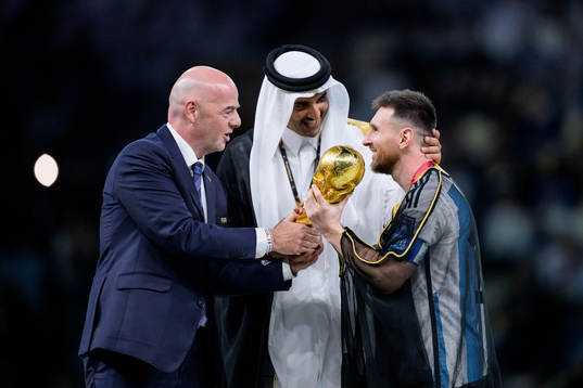 Lionel Messi of Argentina is handed the FIFA World Cup