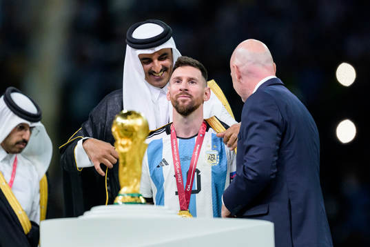 Lionel Messi of Argentina is handed a piece of clothing