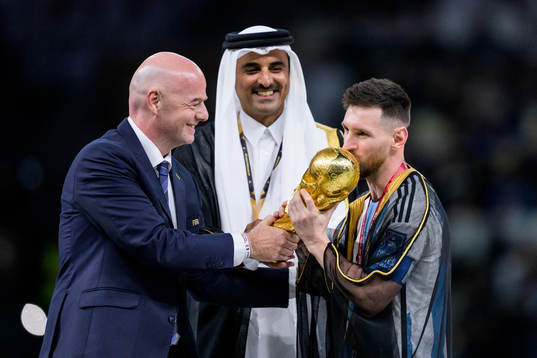 Lionel Messi of Argentina is handed the FIFA World Cup