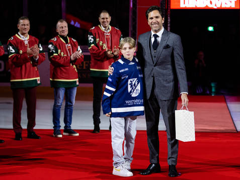 En ung ishockeyspelare uppvaktar Henrik Lundqvist