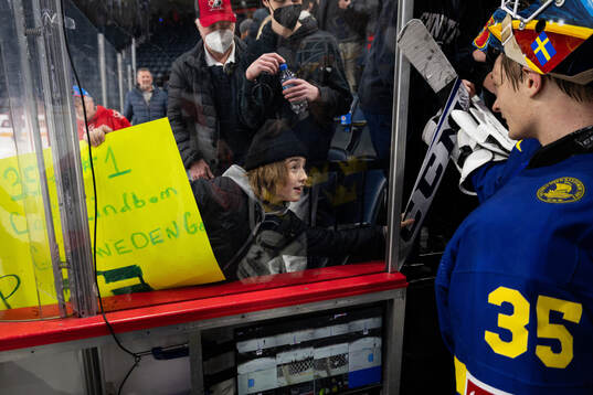 A fan receives a signed stick from goaltender Carl Lindbom