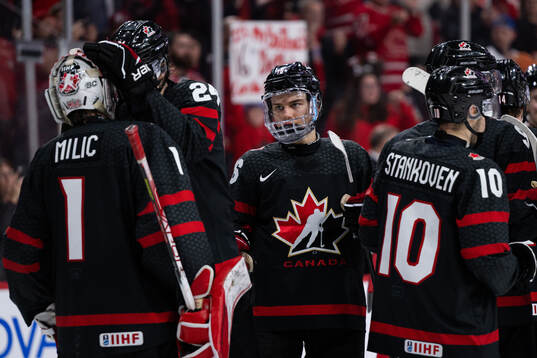 Connor Bedard and goalkeeper Thomas Milic of Canada