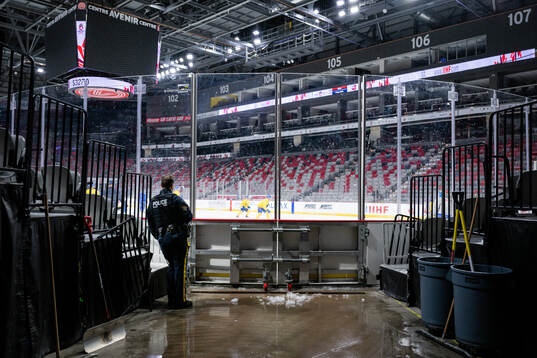 A police officer watches a practice session with Team Sweden