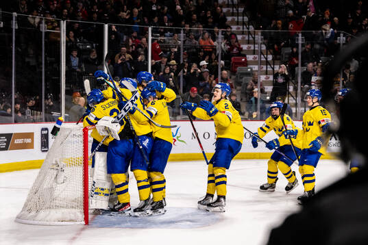 Players of Sweden celebrate with goaltender Carl Lindbom