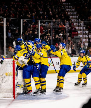 Players of Sweden celebrate with goaltender Carl Lindbom