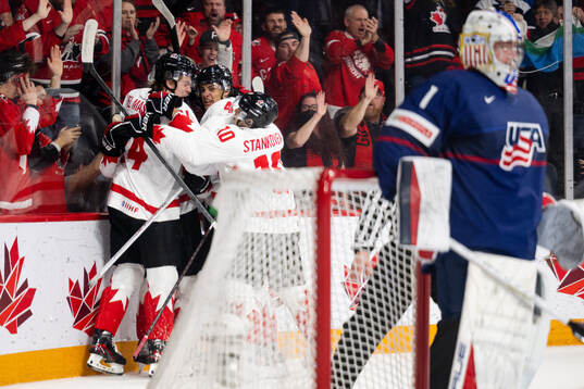 Ethan Del Mastro and Connor Bedard of Canada celebrates the