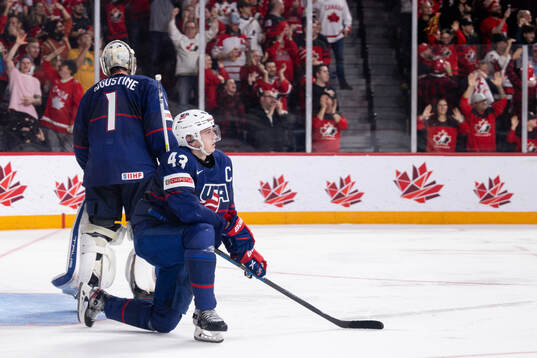 Luke Hughes and goaltender Trey Augustine  of USA look