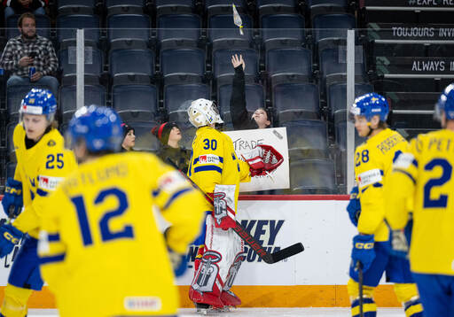 Goaltender Marcus Brännman of Sweden trades a puck for