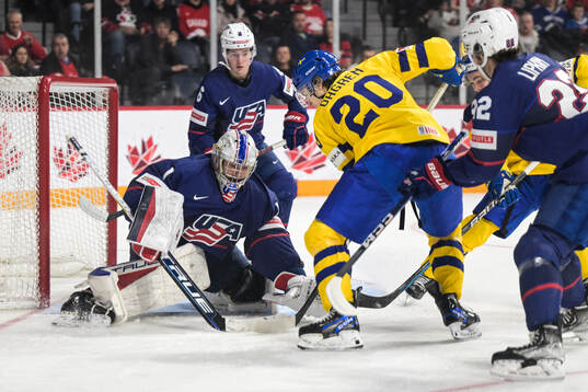 Liam Öhgren of Sweden infront of goaltender Trey Augustine