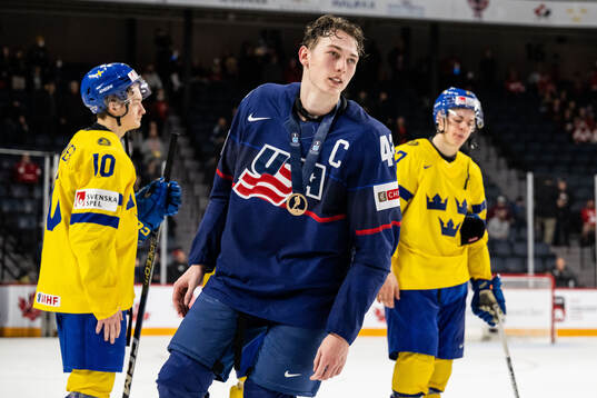 Luke Hughes of USA celebrates with his bronze medal
