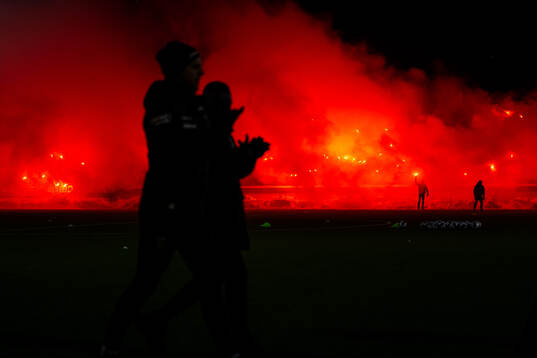Supportrarna bränner bengaler när spelarna gör entré