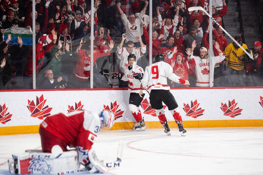 Dylan Guenther and Joshua Roy of Canada celebrate the game