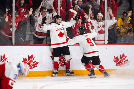 Dylan Guenther and Joshua Roy of Canada celebrate the game
