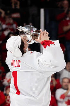 Goalkeeper Thomas Milic of Canada celebrates with the trophy