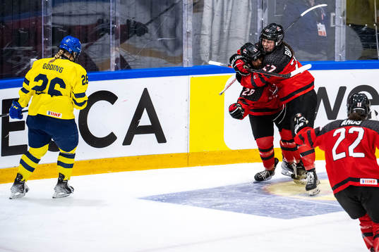 Emma Goding of Sweden looks dejected and players of Canada