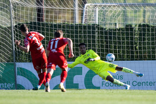 Mathias Rasmussen of Brann scores behind goalkeeper Oliver