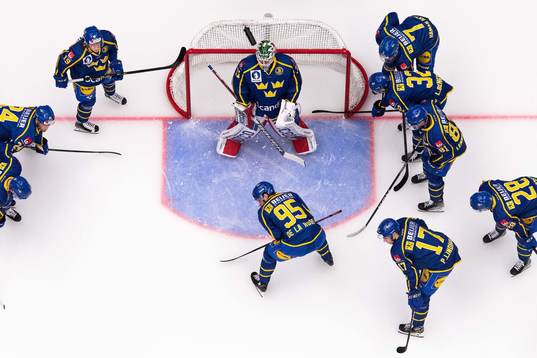 Players of Sweden gather around goaltender Lars Johansson