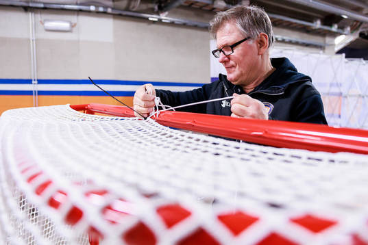 Vaktmästare Göran Krantzmonterar nät på målbur före
