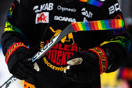 Klubba med regnbågsfärgad tejp på bladet