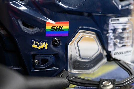 Hjälm med regnbågsfärgad SHL-logo i omklädningsrummet