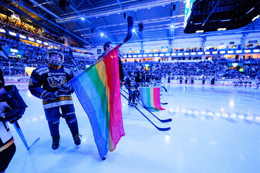 Juniorer håler prideflaggor vid lineup innan