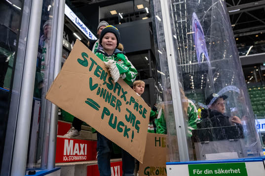 Supporter med en skylt med text ”Sten, Sax,Påse”