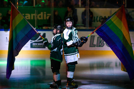 Två ungdomar med pride flaggor
