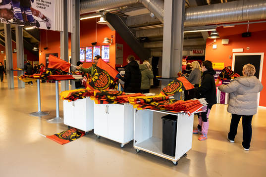 Flaggor delas ut bakom läktaren