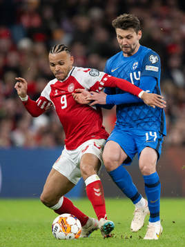 Martin Braithwaite of Denmark and Kaan Kairinen of Finland