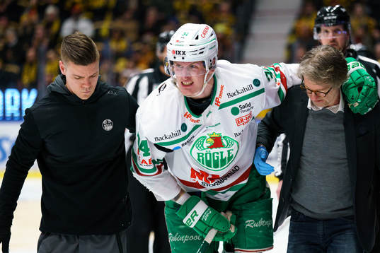 Rögles Adam Edström får hjälp att skadad ta sig av isen