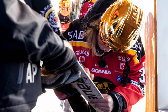 Frida Axell  skriver autograf på klubba