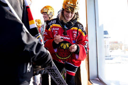 Frida Axell skriver autograf på klubba