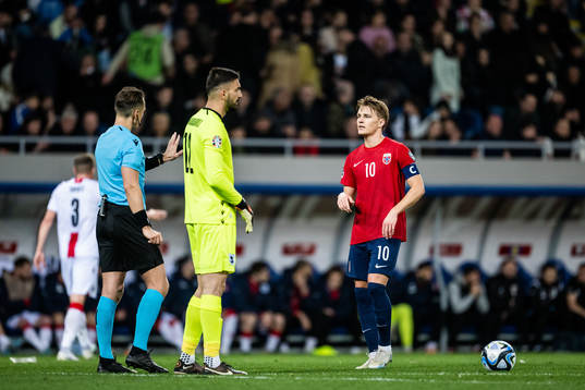 Referee Andris Treimanis and Martin Ødegaard of Norway