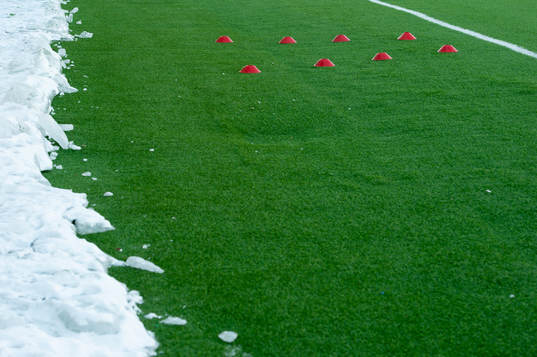 Snö och konstgräs innan fotbollsmatchen i Superettan