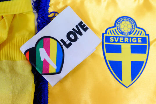 The One Love captains armband next to the logo of the