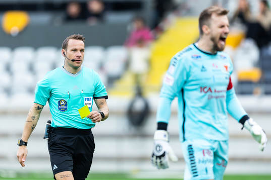 Domare Kristoffer Karlsson delar ut ett gult kort till