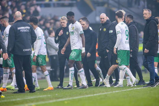 Hammarbys spelare lämnar planen då matchen pausats på