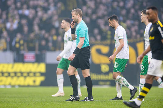 Domare Glenn Nyberg lämnar planen då matchen pausats på