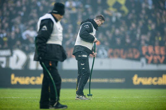 Friends Arena personal underhåller gräsmattan i ett