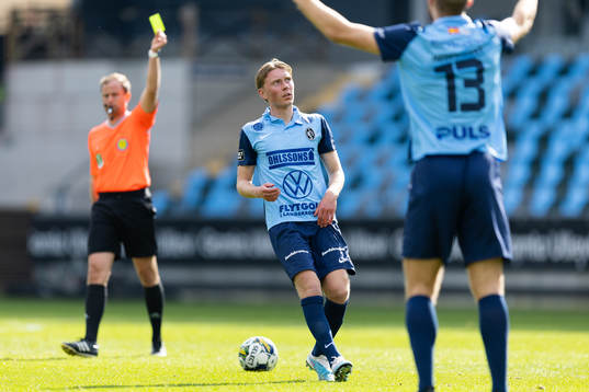 Domare Richard Sundell delar ut ett gult kort till