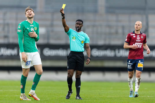 Domare Fredrik Oppong delar ut ett gult kort till