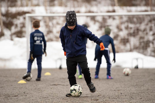 En spelare driver en boll på grus när Kovlands IF P