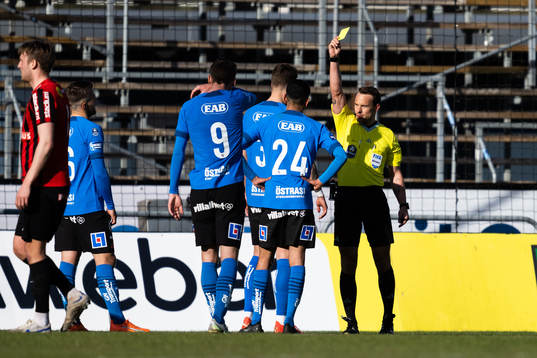 Domare Kristoffer Karlsson delar ut gult kort